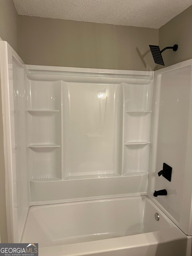 bathroom with shower / bathtub combination and a textured ceiling