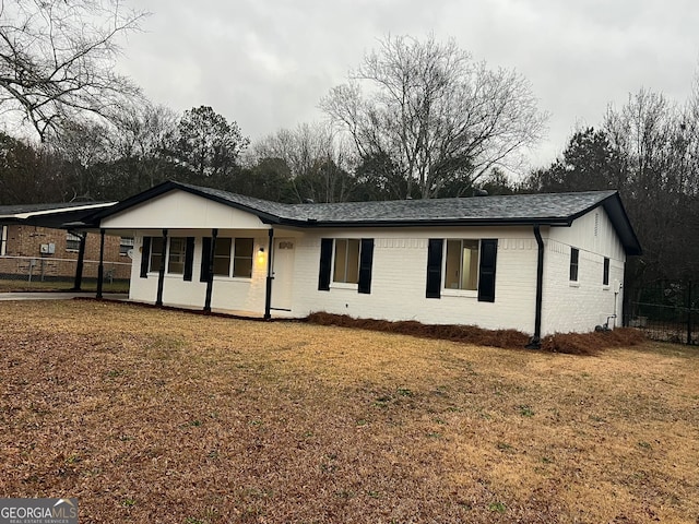 single story home with a front lawn and a carport