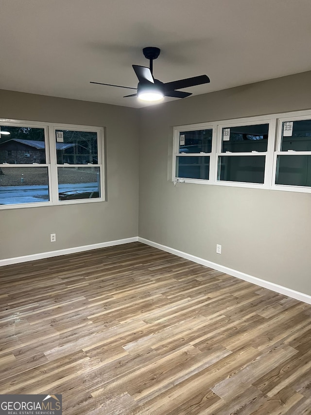 empty room with hardwood / wood-style flooring and ceiling fan