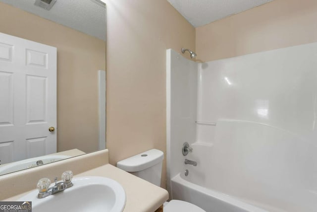 full bathroom featuring shower / bathtub combination, vanity, toilet, and a textured ceiling