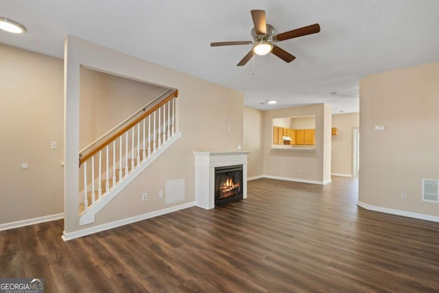 unfurnished living room with dark wood-type flooring and ceiling fan