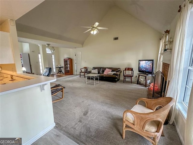 living room with ceiling fan, light colored carpet, and high vaulted ceiling