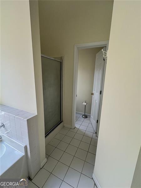 bathroom with tile patterned floors and independent shower and bath