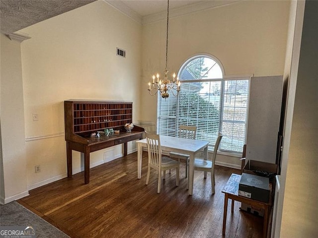 dining space featuring crown molding, dark hardwood / wood-style flooring, a high ceiling, and a notable chandelier