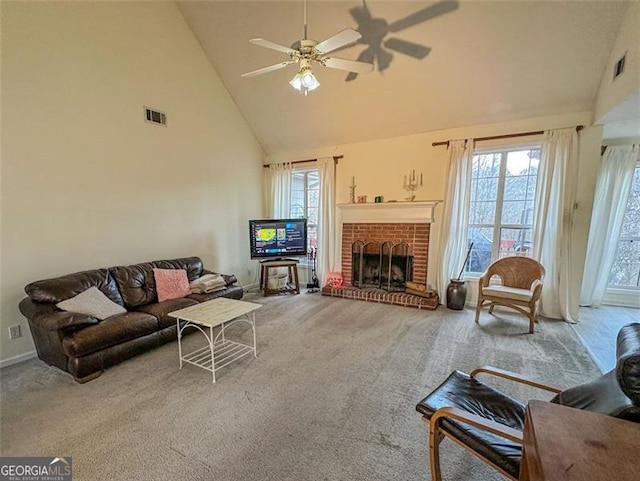 carpeted living room with ceiling fan, a fireplace, and high vaulted ceiling