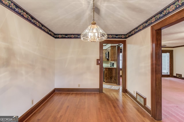 unfurnished dining area with hardwood / wood-style floors and a chandelier