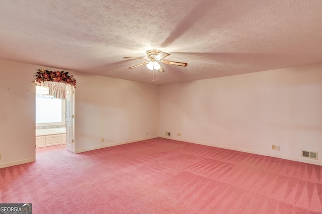 carpeted empty room with ceiling fan and a textured ceiling