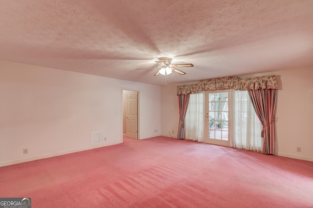 carpeted spare room featuring ceiling fan and a textured ceiling