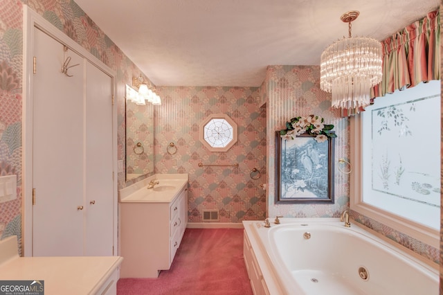 bathroom featuring an inviting chandelier, vanity, and a bathing tub