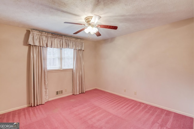 empty room featuring ceiling fan, carpet floors, and a textured ceiling