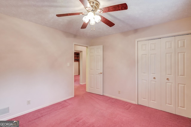 unfurnished bedroom featuring ceiling fan, a closet, carpet flooring, and a textured ceiling