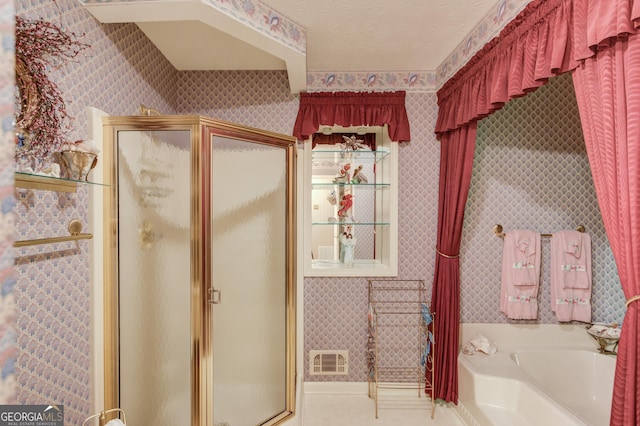 bathroom with plus walk in shower, tile patterned floors, and a textured ceiling