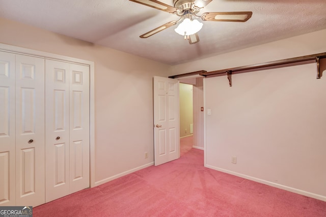 unfurnished bedroom with ceiling fan, a closet, light carpet, and a textured ceiling