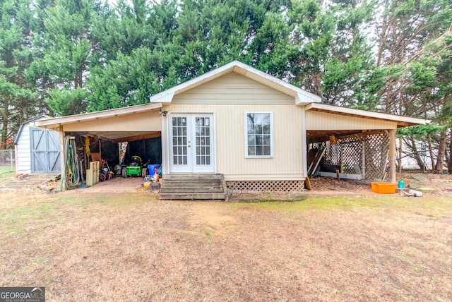 rear view of property featuring an outbuilding and a lawn