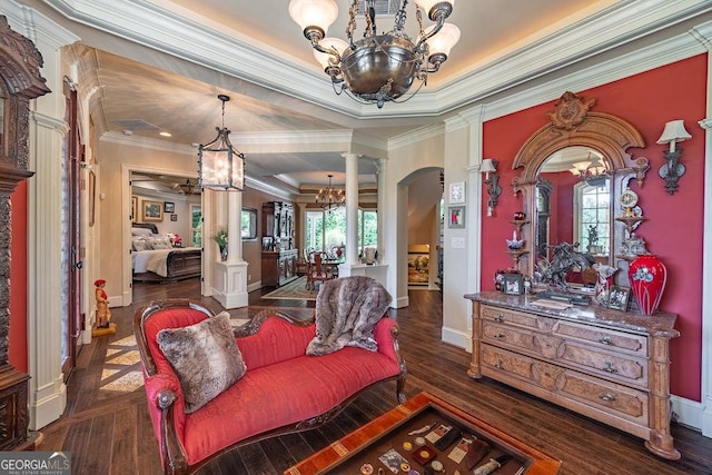 sitting room with ornate columns, a healthy amount of sunlight, dark wood-type flooring, and a chandelier