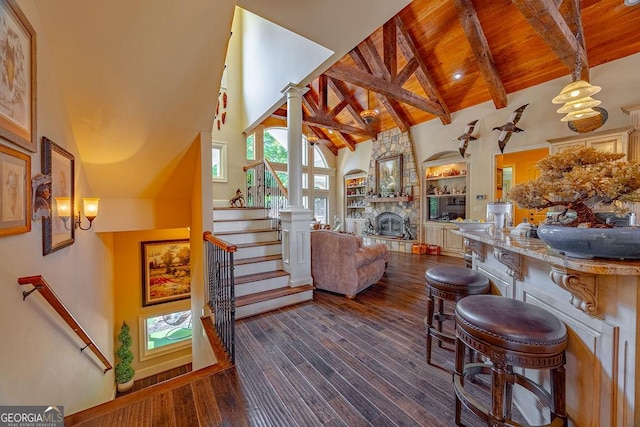 living room with wood ceiling, high vaulted ceiling, a fireplace, dark hardwood / wood-style flooring, and beamed ceiling