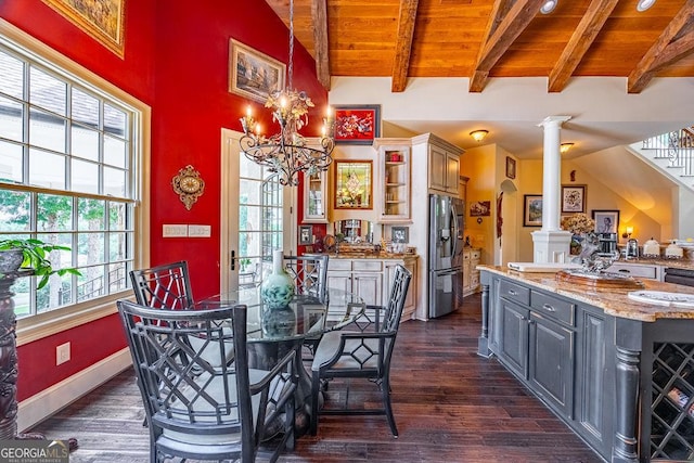 dining area featuring wooden ceiling, dark hardwood / wood-style flooring, a chandelier, and ornate columns