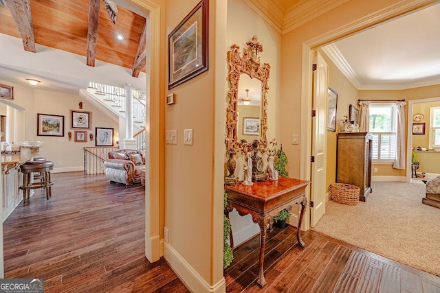 hall featuring beamed ceiling, ornamental molding, dark hardwood / wood-style flooring, and wooden ceiling