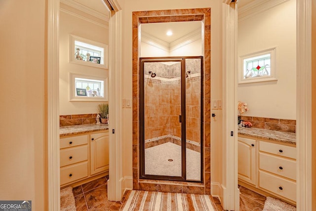 bathroom featuring crown molding, vanity, and a shower with door