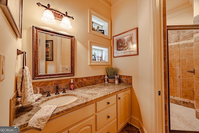 bathroom with vanity, ornamental molding, and a tile shower