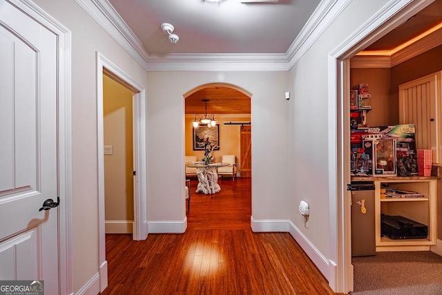 hallway featuring ornamental molding, hardwood / wood-style floors, and a notable chandelier