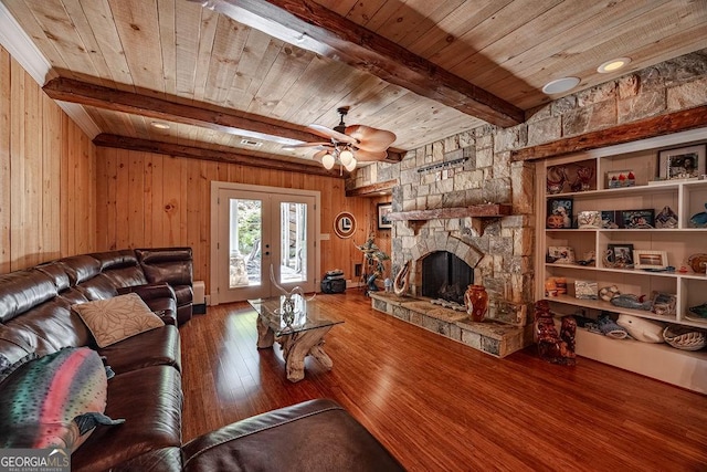 living room featuring french doors, wood ceiling, beamed ceiling, a fireplace, and hardwood / wood-style floors