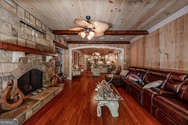 unfurnished living room with hardwood / wood-style flooring, wood ceiling, a stone fireplace, and beam ceiling