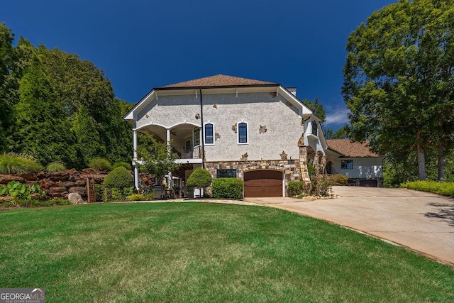 view of front of home featuring a garage, a front lawn, and a balcony