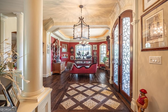 foyer featuring dark wood-type flooring, decorative columns, and french doors