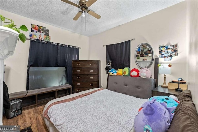 bedroom with hardwood / wood-style flooring, ceiling fan, and a textured ceiling