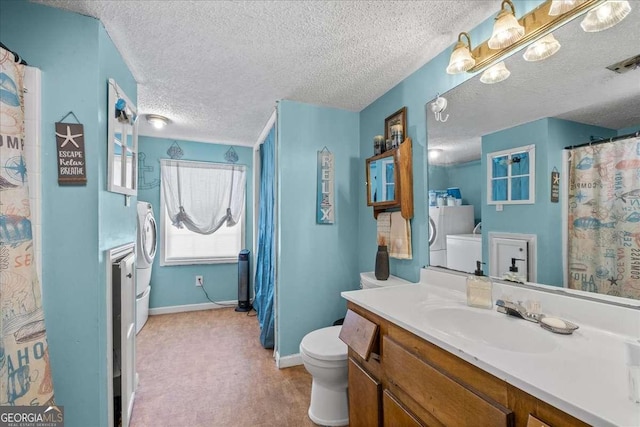 bathroom with vanity, a textured ceiling, toilet, and washing machine and clothes dryer