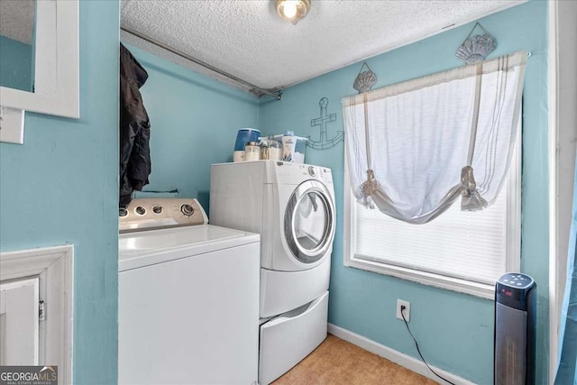 laundry room featuring a textured ceiling and washer and clothes dryer