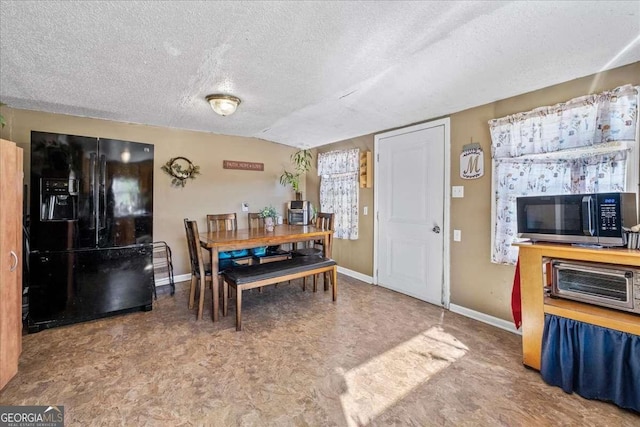 dining space with vaulted ceiling and a textured ceiling