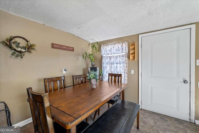 dining room featuring lofted ceiling and a textured ceiling