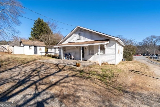 view of front facade with an outbuilding and a porch