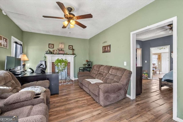 living room with hardwood / wood-style flooring, a textured ceiling, and ceiling fan