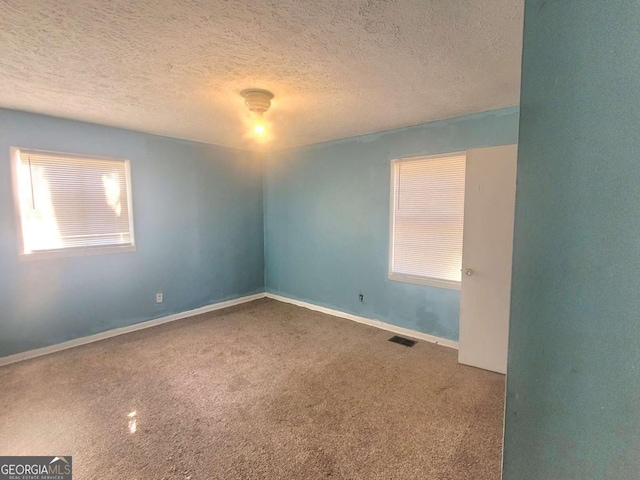 unfurnished room featuring carpet flooring and a textured ceiling