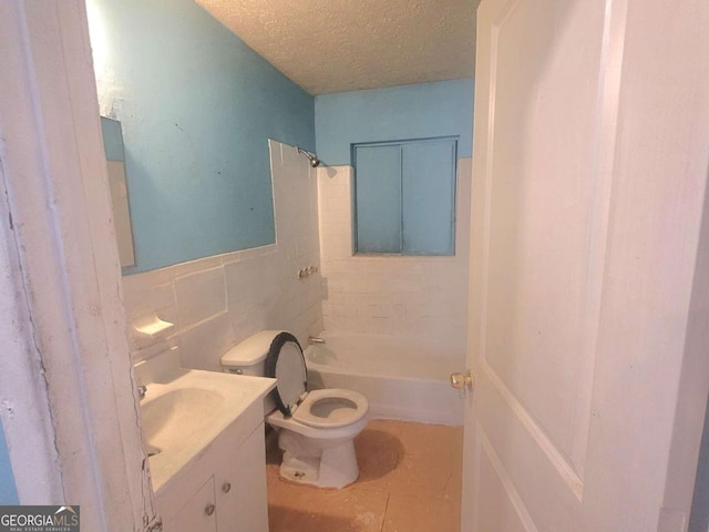 full bathroom featuring tile patterned floors, toilet, tile walls, a textured ceiling, and vanity