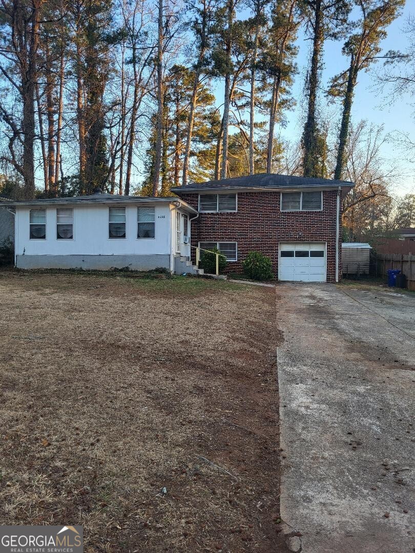 view of front of house with driveway, brick siding, and an attached garage