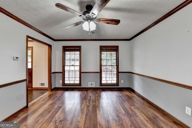 spare room featuring ceiling fan, ornamental molding, dark hardwood / wood-style floors, and a textured ceiling