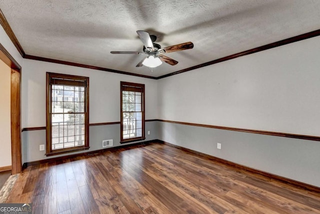 empty room with ceiling fan, ornamental molding, dark hardwood / wood-style floors, and a textured ceiling