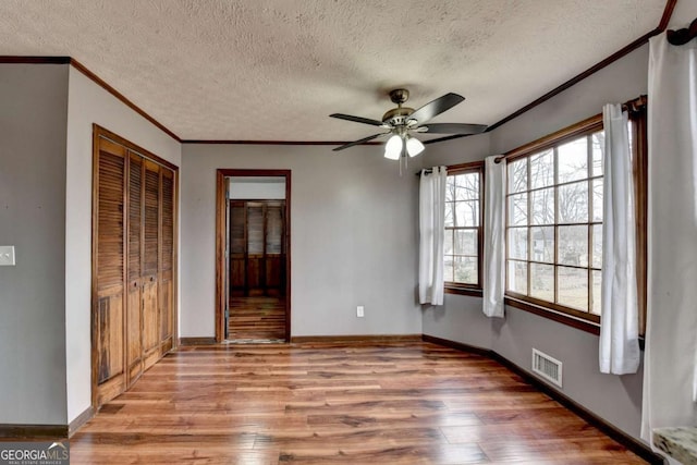 unfurnished bedroom with ornamental molding, light hardwood / wood-style floors, and multiple windows