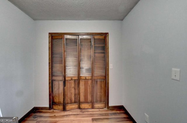 spare room with hardwood / wood-style floors and a textured ceiling