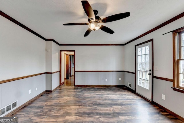 empty room featuring dark hardwood / wood-style flooring, ornamental molding, and ceiling fan