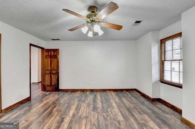 empty room with dark hardwood / wood-style flooring and ceiling fan