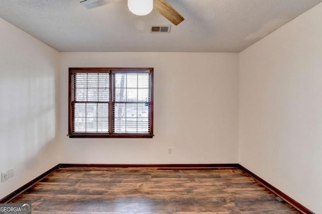 unfurnished room featuring a textured ceiling, dark hardwood / wood-style floors, and ceiling fan