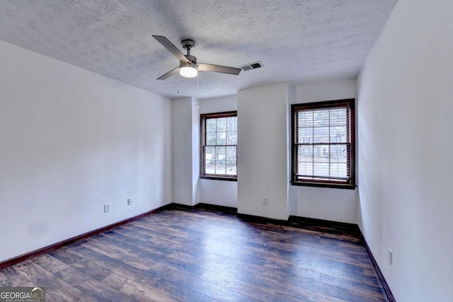 unfurnished room with dark hardwood / wood-style floors, a textured ceiling, and ceiling fan