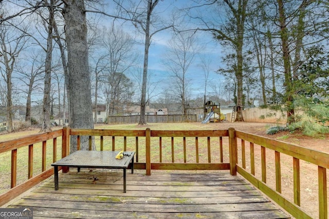 wooden terrace featuring a playground and a lawn