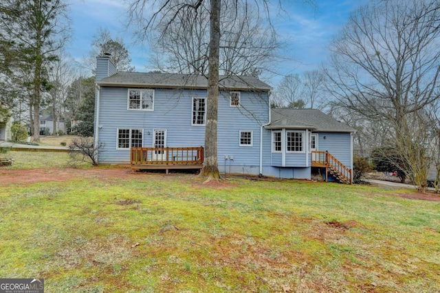 rear view of house featuring a wooden deck and a yard