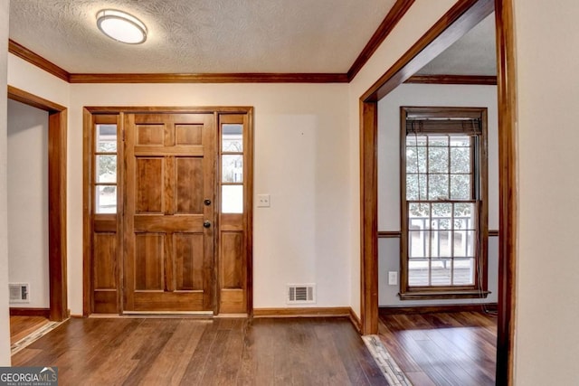 foyer featuring dark wood-type flooring, crown molding, and a textured ceiling